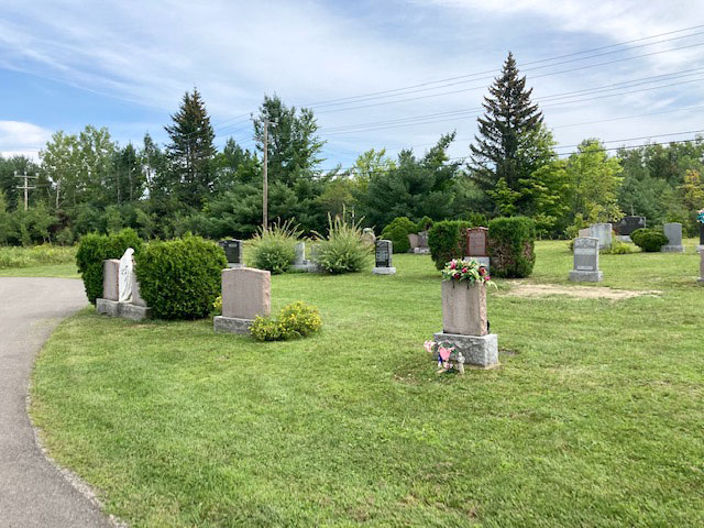 Arbustes et fleurs à raser dans un cimetière de Prévost